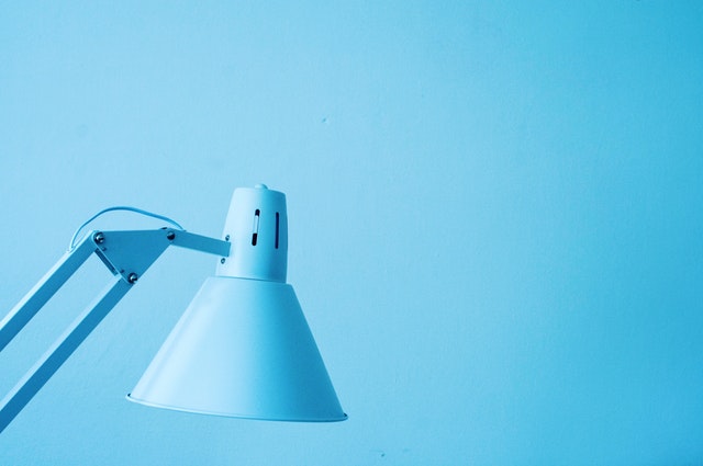 Modrá stolová lampa pred modrou stenou.jpg